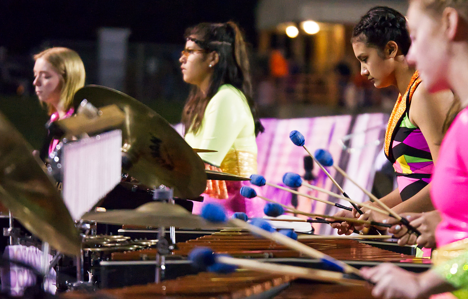 Mallet players for the Sound of the Swarm Mineola High School marching band, part of the percussion “pit” keep the beat during the disco-themed halftime show.